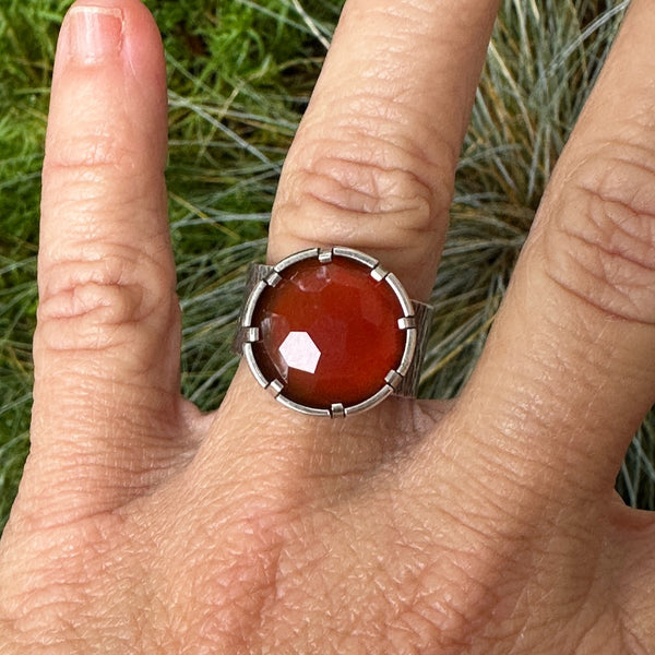 Sterling silver and faceted carnelian ring, deep orange color with 8 ab settings, wide textured band, silver is oxidized to darken and bring out texture.